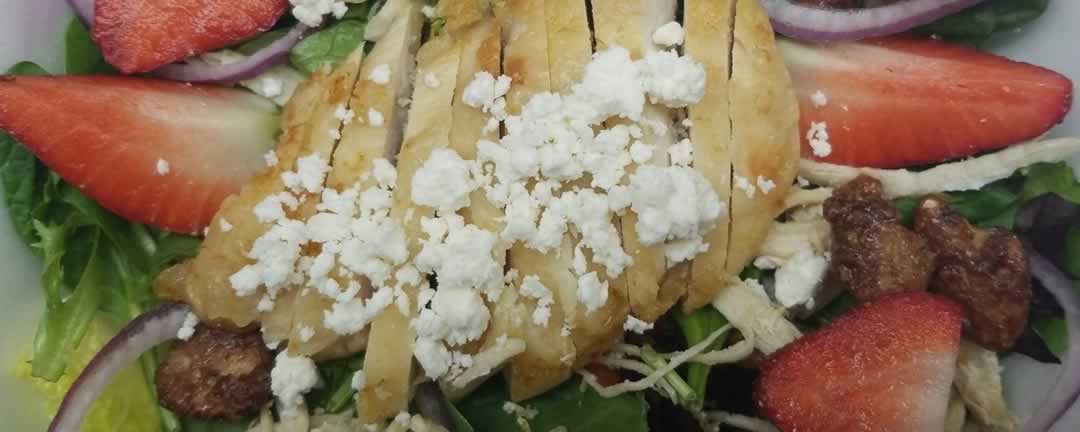 Strawberry Chicken Salad with mixed greens, asparagus, feta cheese, praline pecans and our special dressing